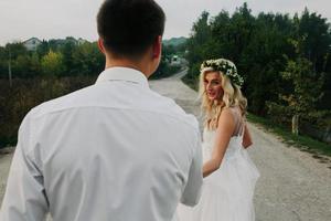 bride leads groom on the road photo