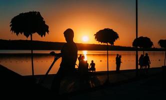 people are resting on a sports field by the river bank photo