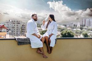 flirting couple with sparkling wine on a roof photo