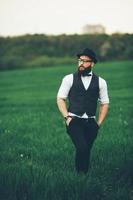 un hombre con barba y gafas de sol caminando por el campo foto