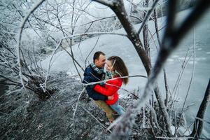 beautiful couple posing near a frozen river photo