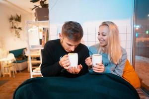 chico con una chica bebe café caliente y té foto