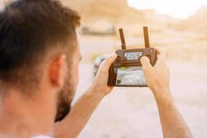 Guy controls drone with remote control photo