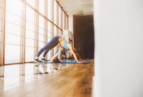 Mother and daughter stretching back in the gym photo