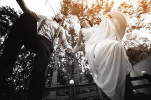 bride and groom jumping, having fun photo