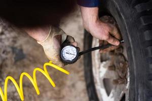 A man pumps air wheel with a compressor photo