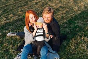 feliz mamá papá e hijo abrazándose en el parque foto