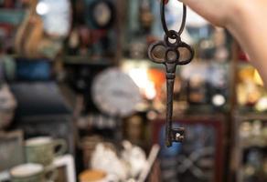 woman's hand holding an antique key on blurred background photo