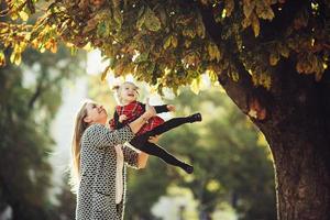 Mother and little daughter playing in a park photo