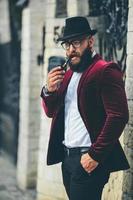 rich man with a beard smokes electronic cigarette photo