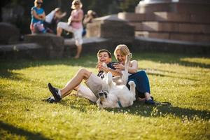 niño y niña con perro yacen en la hierba foto