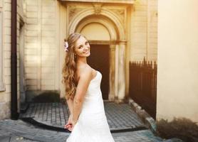 Beautiful bride posing against the backdrop of a European city photo