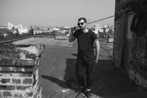 The man in the authentic boots and jeans selvedge on the roof of the building in the old town photo