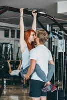 chico besa a la novia en el entrenamiento en el gimnasio foto