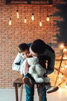 Dad and son on a background of a brick wall photo