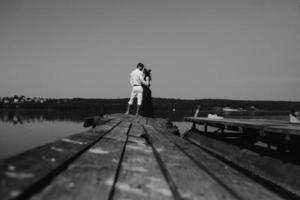 Hugging man and woman in love on wooden pier photo