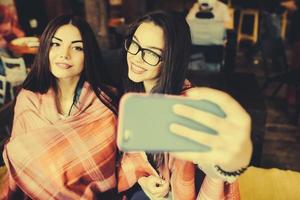 dos amigos cercanos hacen selfie en la cafetería foto