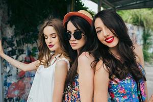 Three beautiful young girls at the bus stop photo