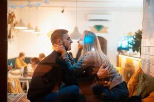 Photo through window. Young couple in cafe with stylish interior