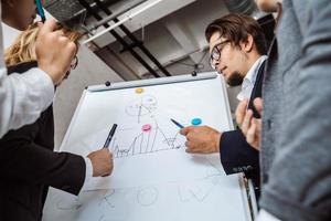 empresarios con pizarra discutiendo estrategia en una reunión foto