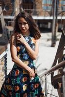 Young girl in a dress posing on a street photo