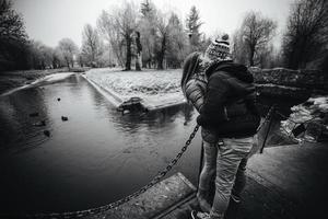 beautiful couple is standing on a small bridge photo