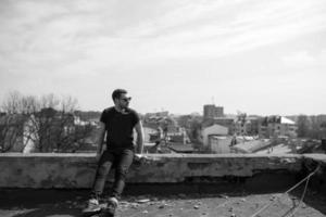 The man in the authentic boots and jeans selvedge on the roof of the building in the old town photo