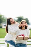 Two beautiful girls and gift photo