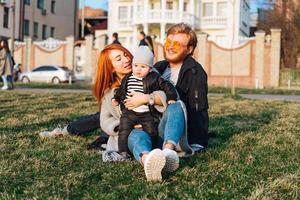 happy mom dad and son hugging in the park photo