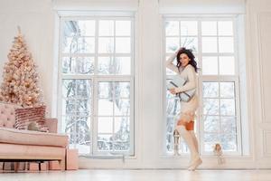 Beautiful young girl in white dress posing on camera. Christmas concept photo