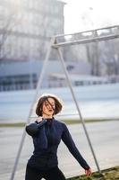 Mujer joven haciendo ejercicio con pesas rusas afuera en el estadio foto