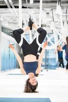 Woman hanging upside down in a hammock. Fly yoga class. photo