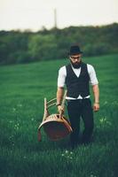 Bearded man carries a chair on the field photo