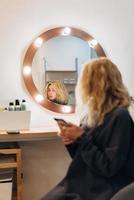 mujer atractiva en el espejo en el estudio de belleza foto