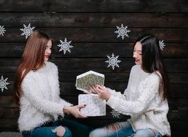 dos chicas jóvenes con un brillante regalo de vacaciones foto