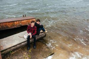 Two friends relaxing on the pier. photo