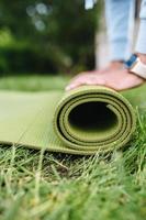 Close-up of woman folding roll fitness after working out in the park photo