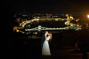 encantadora novia y novio en un fondo de budapest foto