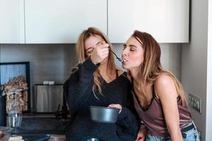 two girls eat porridge at home photo