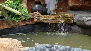 bellissimo sollievo stagno nel il giardino, con un' cascata, 4k metraggio risoluzione video