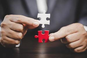 Business woman person hand holding puzzle piece idea for strategy and solution. Closeup part of two white jigsaw connect together. Concept of join cooperation success teamwork-problem corporate team photo