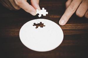 Business woman person hand with puzzle piece idea for strategy and solution. Closeup part of two white jigsaw connect together. Concept of join cooperation success teamwork-problem corporate team. photo