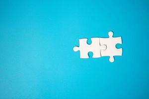 White part of jigsaw puzzle pieces on blue background. concepts of problem solving, business success, teamwork, Team playing jigsaw game incomplete, Texture photo with copy space for text