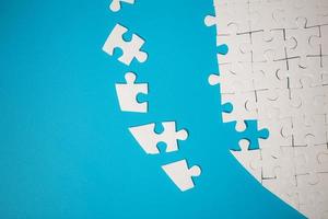 White part of jigsaw puzzle pieces on blue background. concepts of problem solving, business success, teamwork, Team playing jigsaw game incomplete, Texture photo with copy space for text