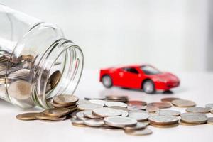 Car toy vehicle with stack coin money on background. Planning to manage transportation finance costs. Concept of car insurance business, saving buy - sale with tax and loan for new car. photo