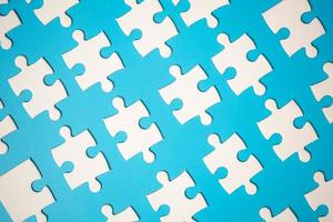 White part of jigsaw puzzle pieces on blue background. concepts of problem solving, business success, teamwork, Team playing jigsaw game incomplete, Texture photo with copy space for text