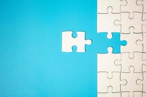 White part of jigsaw puzzle pieces on blue background. concepts of problem solving, business success, teamwork, Team playing jigsaw game incomplete, Texture photo with copy space for text