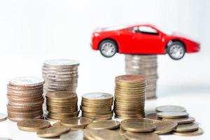 Car toy vehicle with stack coin money on background. Planning to manage transportation finance costs. Concept of car insurance business, saving buy - sale with tax and loan for new car. photo