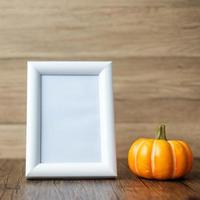 Orange pumpkin on table and frame with copy space for text. Happy Halloween day, Hello October, fall autumn season, Festive, party and holiday concept photo