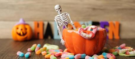 feliz día de halloween con dulces fantasmas, tazón de calabaza, jack o linterna y decorativos. truco o amenaza, hola octubre, otoño otoño, festivo, fiesta y concepto de vacaciones foto